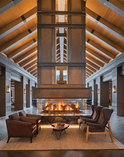 A double-sided fireplace beneath a timber cathedral ceiling